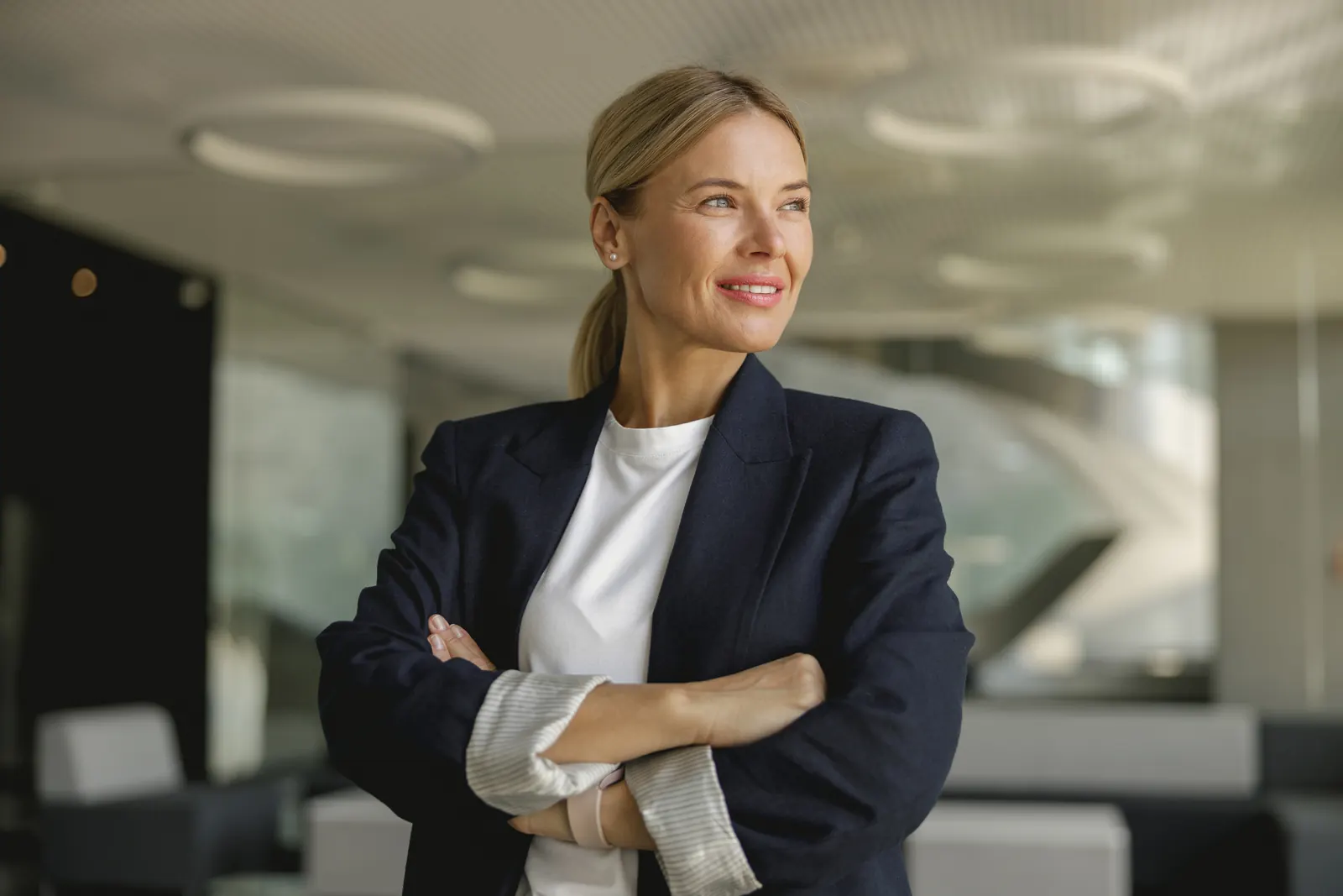 Professionnelle confiante, bras croisés, dans un bureau moderne