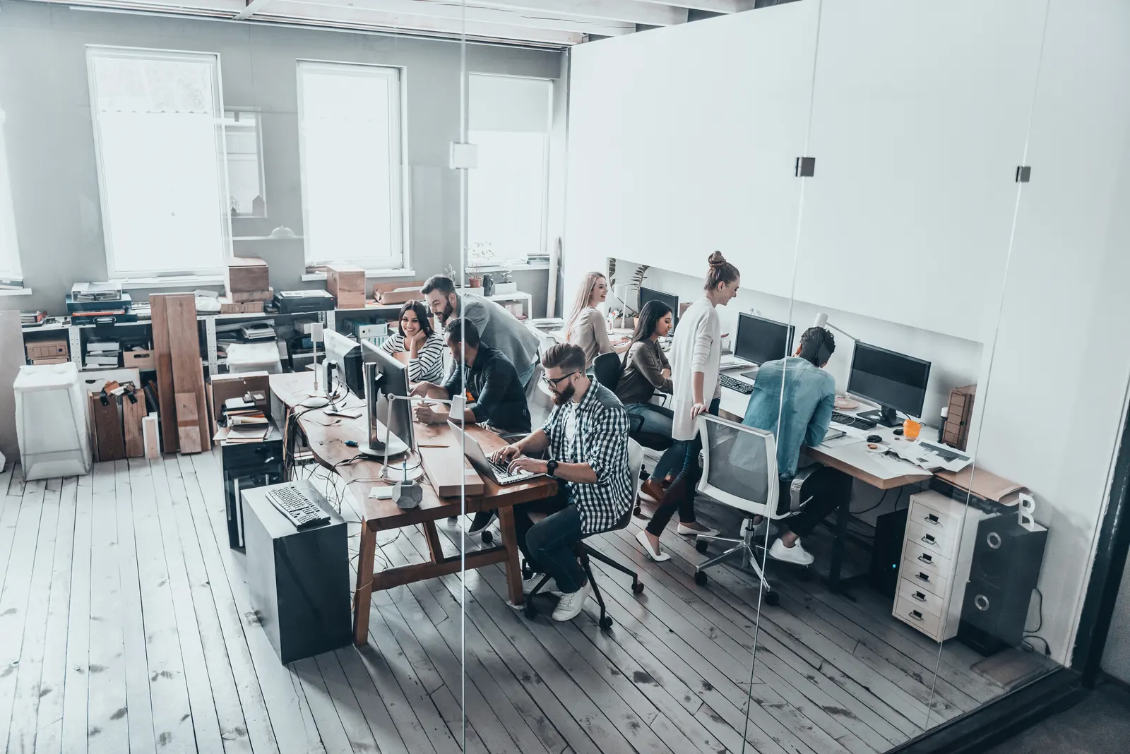 Équipe au travail sur des ordinateurs dans un bureau lumineux